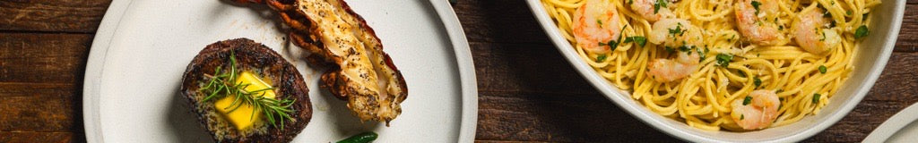 Steak and Lobster on white pate with shrimp past in white dish on wood background