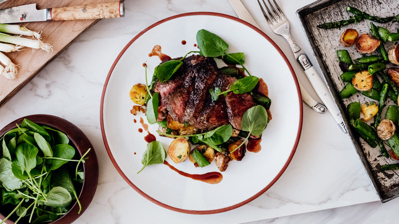 Seared Cap of Ribeye Steak with Roasted Potatoes, Snap Peas, Asparagus and Wine Reduction