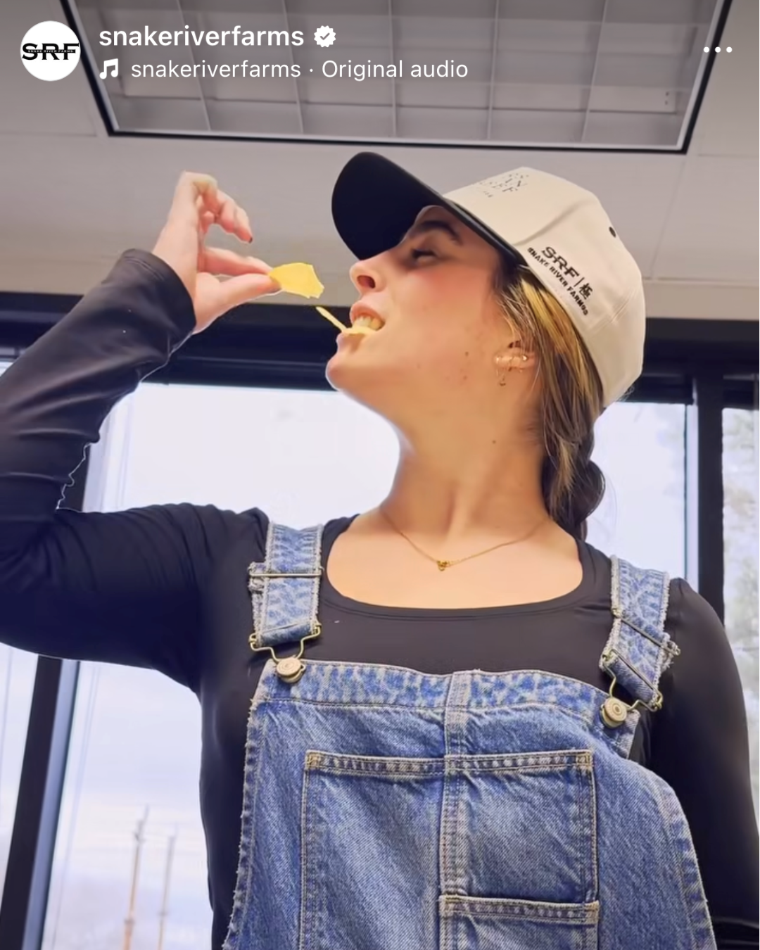 instagram post with a girl eating a chip with SRF hat and overalls