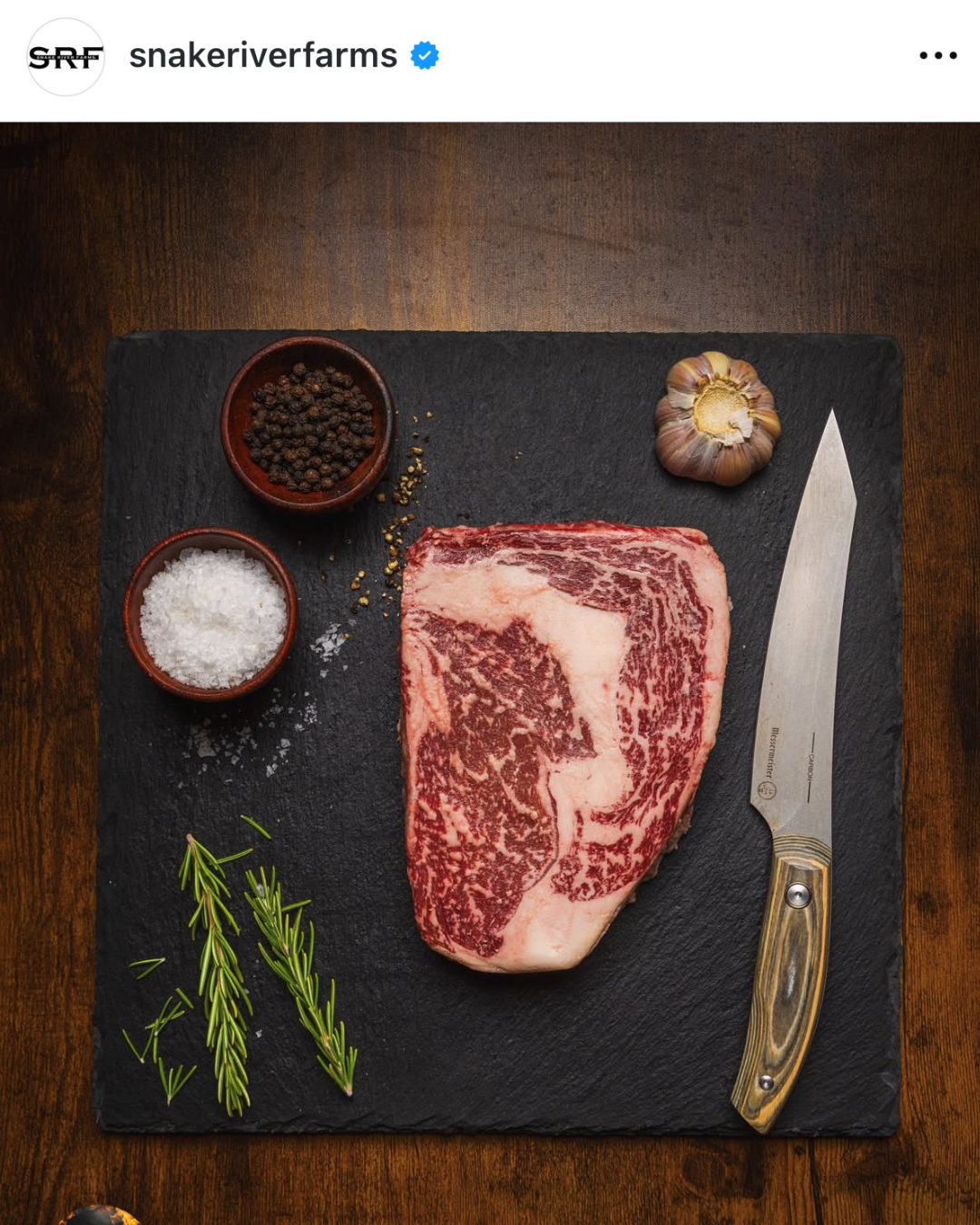 Instagram post on a raw steak, knife, and seasoning on a black cutting board