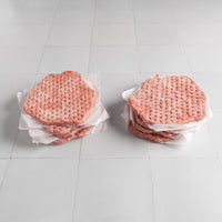 Two stacks of smash burger patties on a white tiled surface