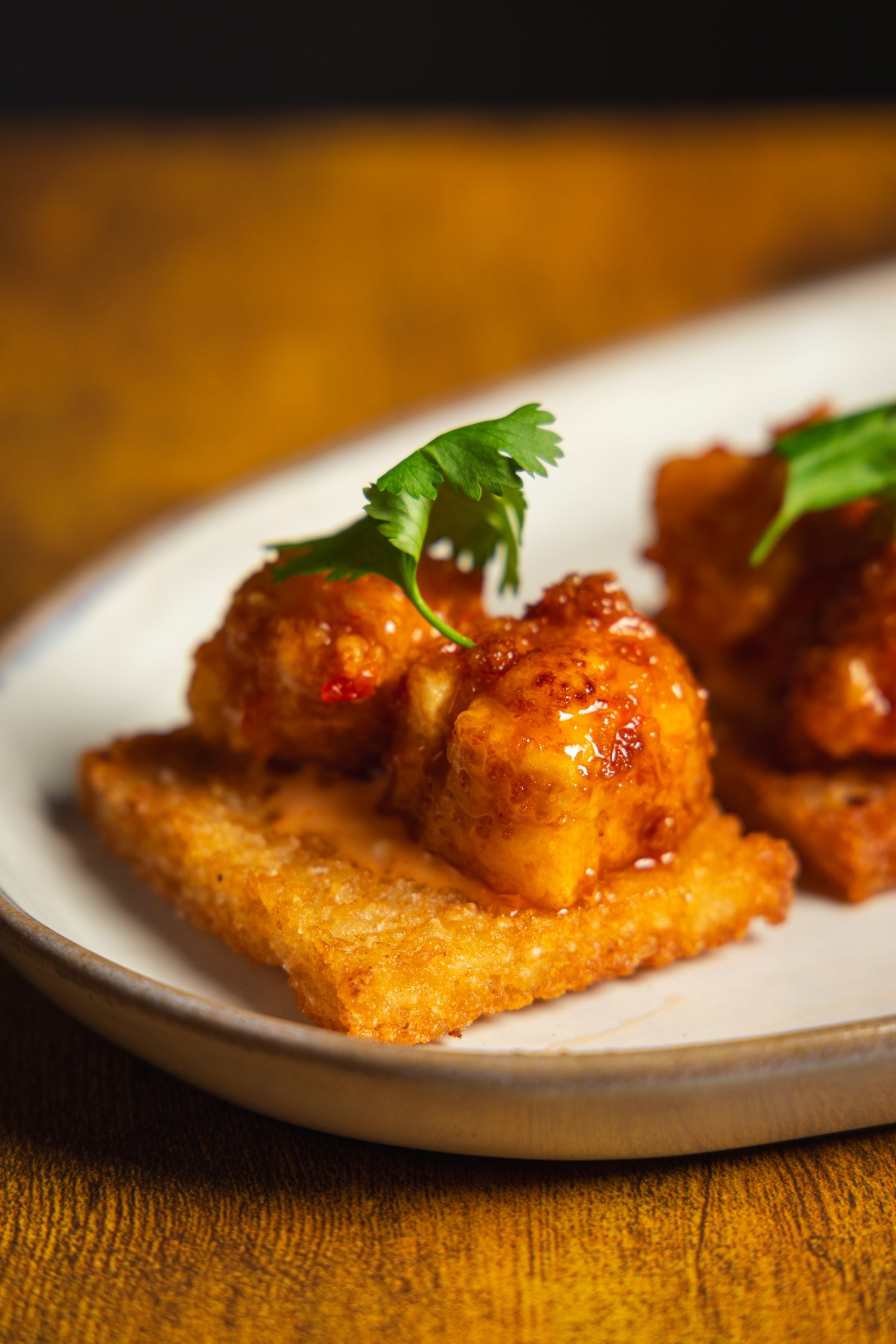 Plated dish with fried food garnished with herbs.
