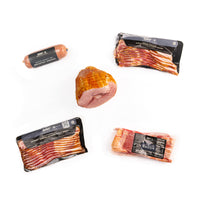 Assorted packages of meat products including a ham, sausages, and bacon on a white background.