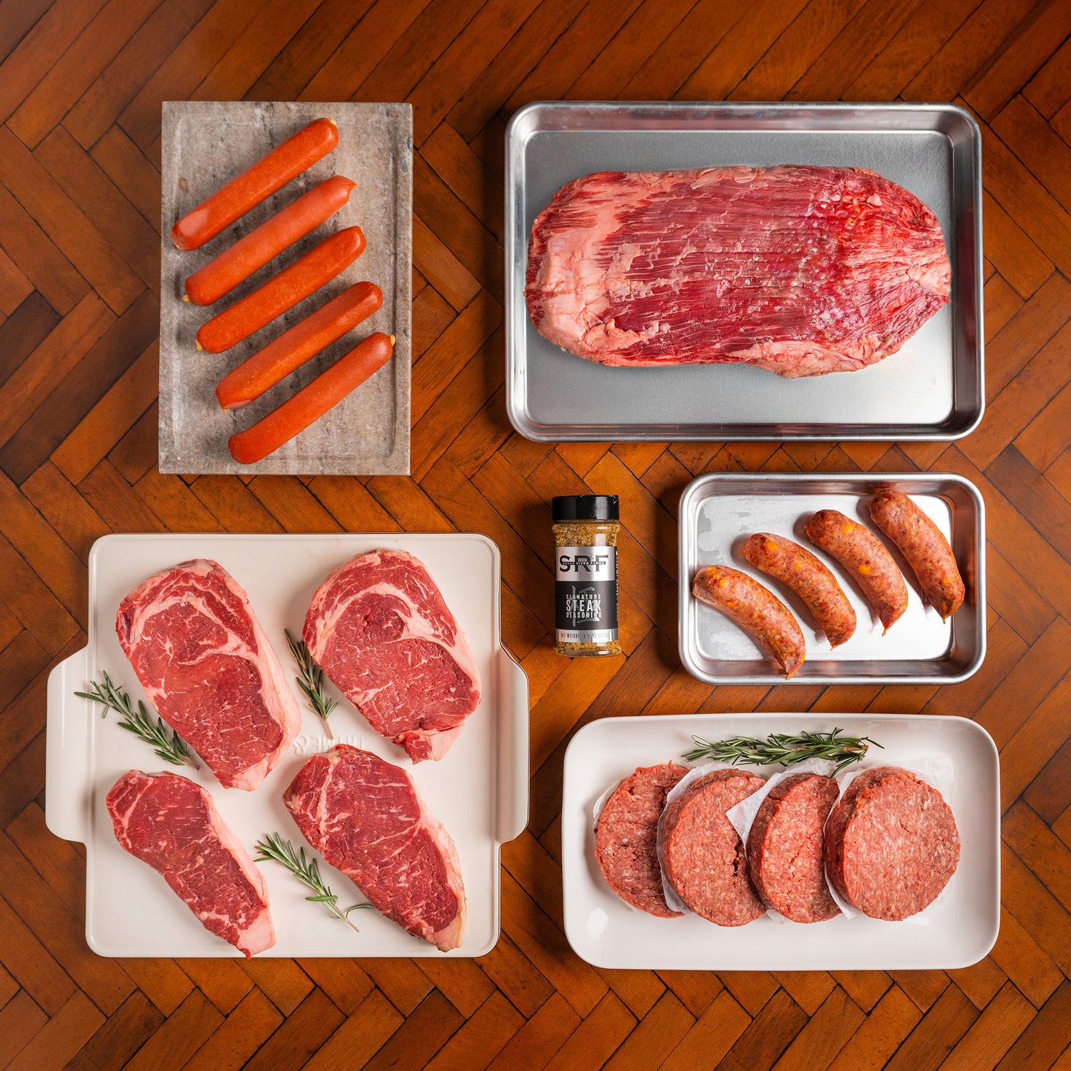 Assorted raw meats on a wooden surface with SRF seasoning.