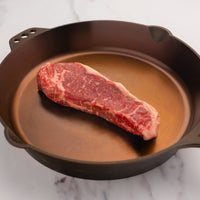 USDA Choice raw steak in cast iron skillet 