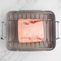 tied prime rib roast on rack in roasting pan 