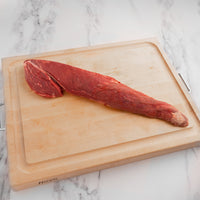 raw tenderloin roast on cutting board 