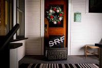 Front door with wreath and SRF boxes on a porch