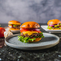 cooked cheeseburgers on plates 