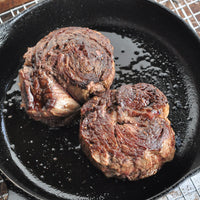 cooked rolled cap of ribeye steaks in cast iron pan 