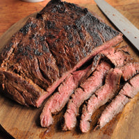 cooked and sliced bavette on cutting board 