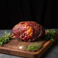 cooked prime rib on cutting board with herbs