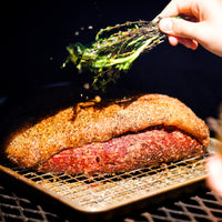 Picanha being cooked on grill with herbs 