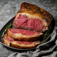 cooked striploin roast on plate with rosemary sprigs 