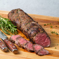 Cooked tenderloin roast sliced on cutting board 