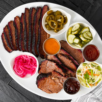 smoked brisket on plate with sides and sauces 