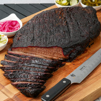 smoked and sliced brisket on cutting board with knife