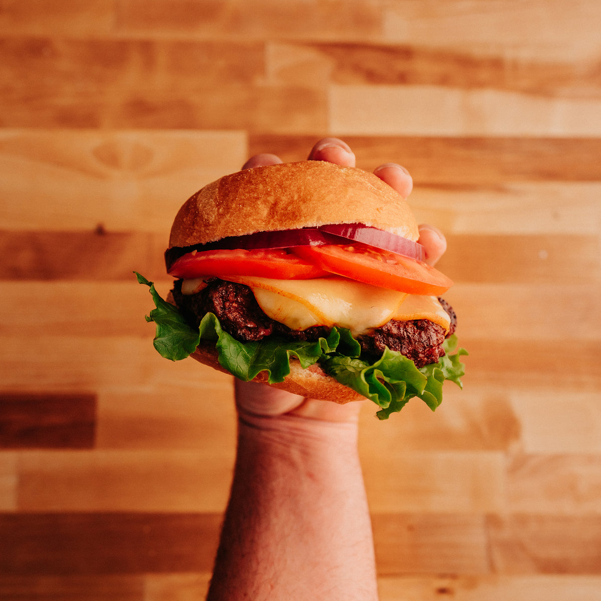 hand holding a Cheeseburger 