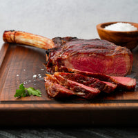 Cooked and sliced Tomahawk with salt on cutting board