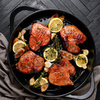 cooked pork porterhouse in cast iron skillet with lemon, garlic and thyme 