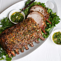 herb crusted cooked rack of pork plated with parsley 