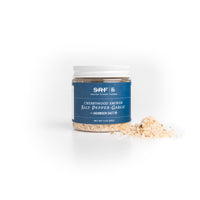 Jar of cherrywood smoked salt with a blue label on a white background