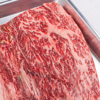 Close-up of marbled red meat on a metal tray