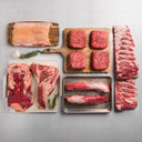 A variety of fresh meats including wagyu ground beef bricks, a flank steak, pork tenderloin, bacon, tri-tip, and spare ribs from Snake River Farms.