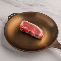 raw boneless pork chop in cast iron skillet 