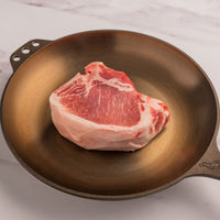 raw pork porterhouse in skillet 