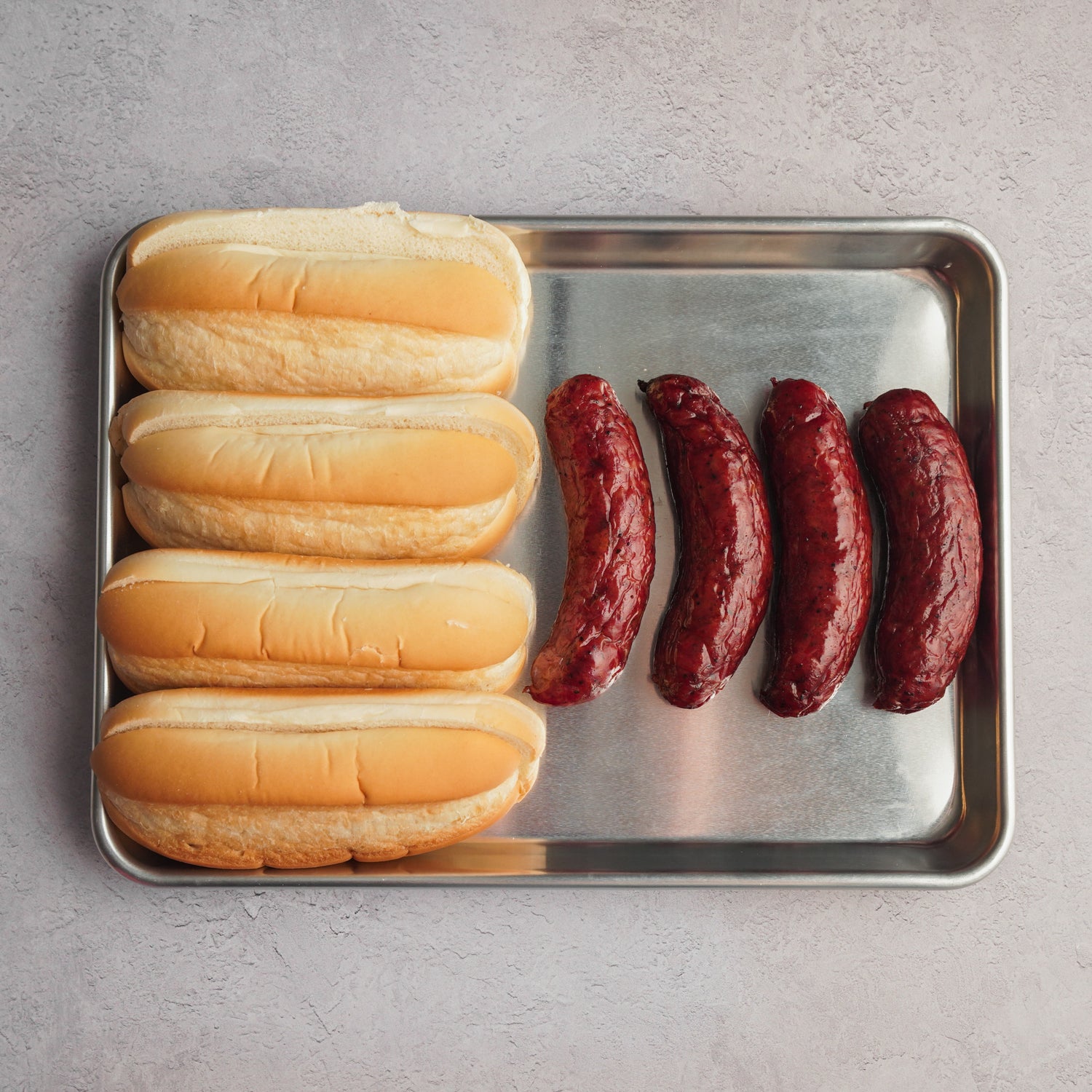 cooked spicy beef sausages with buns on pan 