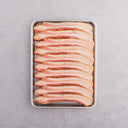 A tray of hickory smoked uncured maple bacon slices arranged neatly, ready for cooking.