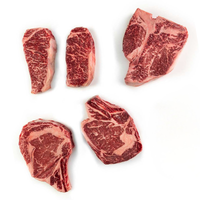 Five cuts of raw steak on a white background