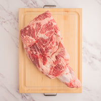 raw pork shoulder on cutting board 