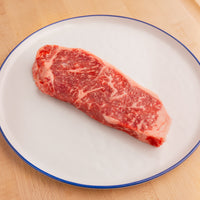 USDA Prime raw steak on white plate 