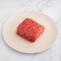 raw wagyu ground beef out of package on white plate 