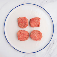 four wagyu slider patties on a white plate