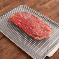 raw flank steak on rack and pan 