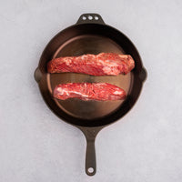 raw hanger steaks in cast iron pan 