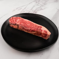 raw SRF Black® NY strip steak on black plate |SRF Black®|1"|1.5"