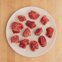 Raw tenderloin pieces on a white plate 