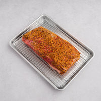 corned beef brisket on rack with traditional seasoning 