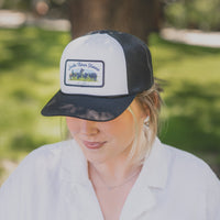 Person wearing a black and white cap with a logo outdoors