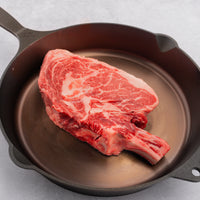 raw cowboy steak in skillet 