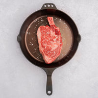 cowboy steak with salt in cast iron skillet 