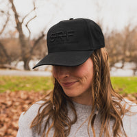 Person wearing a black cap with 'SRF' logo outdoors