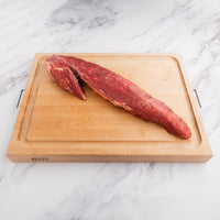 raw tenderloin roast on cutting board 