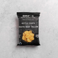 Bag of Snake River Farms kettle chips cooked in Wagyu beef tallow on a gray background