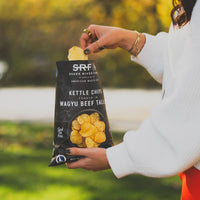 Person holding a bag of Snake River Farms kettle chips outdoors