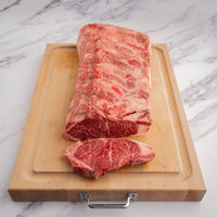 striploin with steak cut off on cutting board 